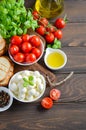 Italian food ingredients Ã¢â¬â mozzarella, tomatoes, basil and olive oil on rustic wooden table. Royalty Free Stock Photo